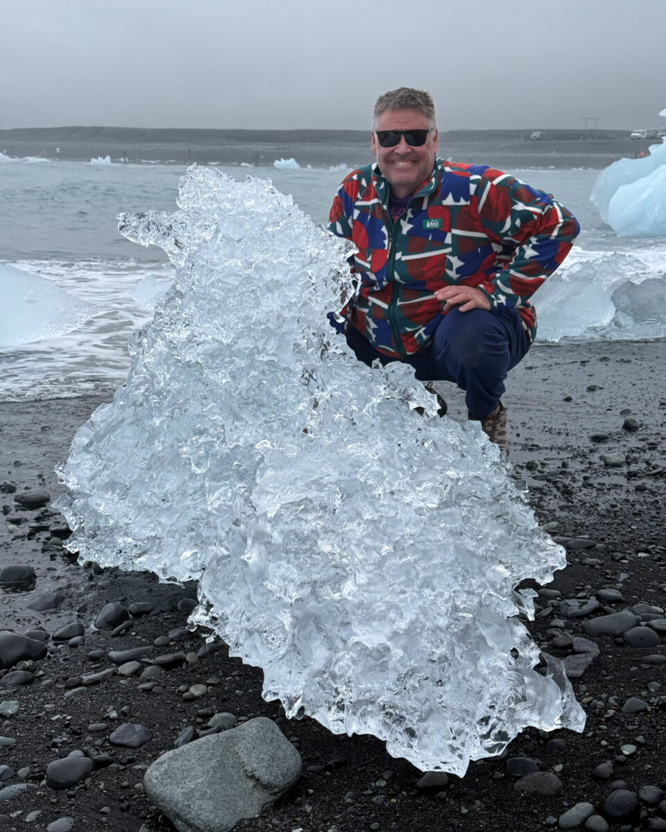 Pete beside a much larger iceberg at Diamond Beach