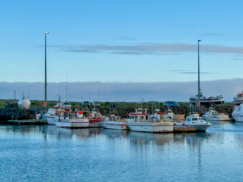 A number of boats in the water at the harbor in Hofn
