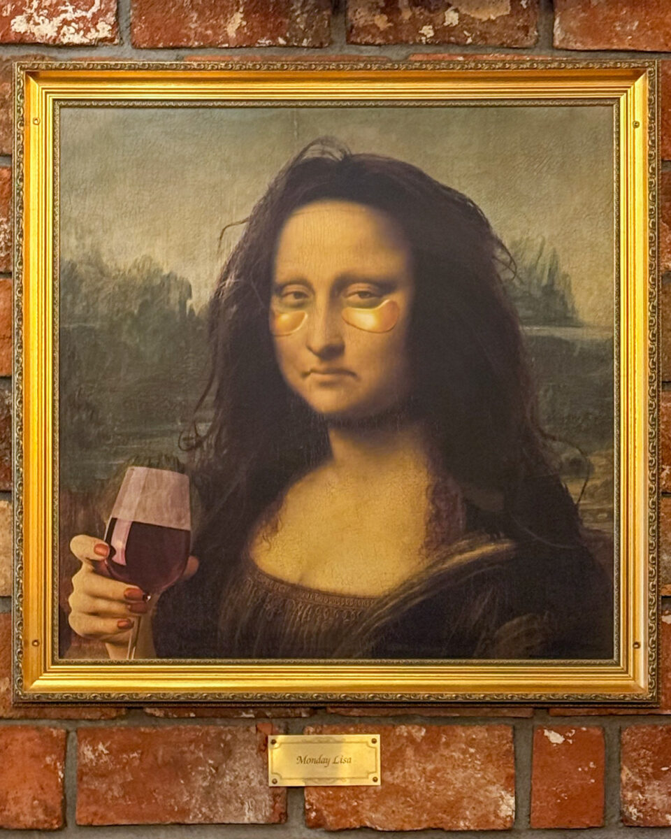 A poster of Mona Lisa with a glass of wine, messed up hair, and under-eye masks