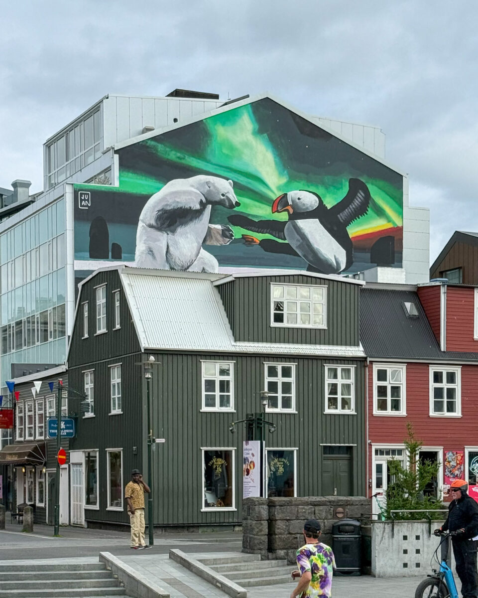 A cartoon-like mural depicting a fight between a polar bear and a puffin